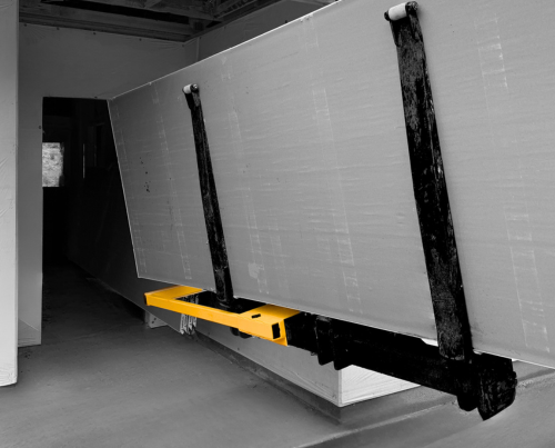 Rockslide attached to boom lift carrying drywall into a construction job
